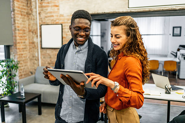 istock Smiling business colleagues using digital tablet in modern office 2213051685