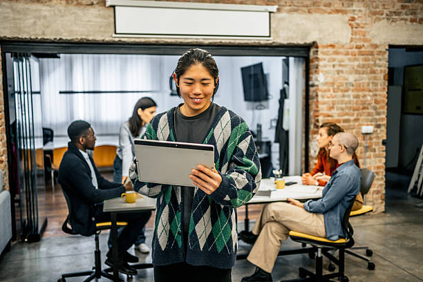 istock Young asian manager using digital tablet in startup office with team 2213051782