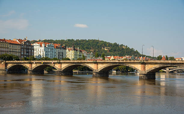 istock Historic bridge in Prague with red trams 2213052125