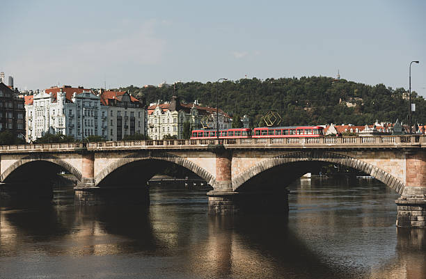 istock Historic bridge in Prague with red trams 2213052128