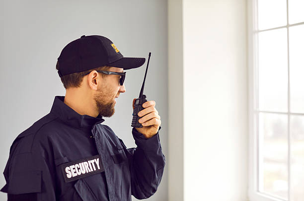 istock Male security guard using portable radio transmitter indoors 2213053583