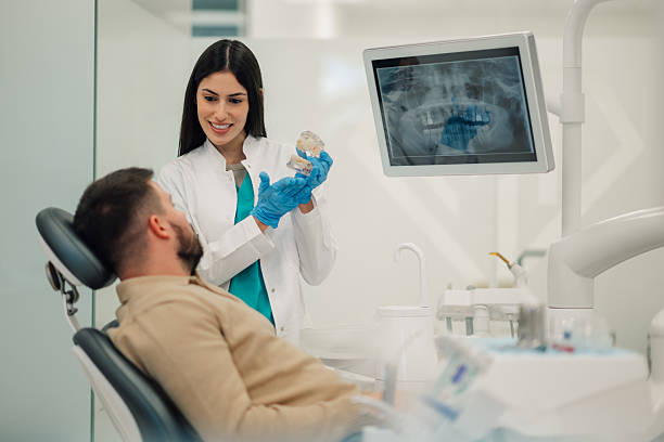 istock Dentist showing teeth model to patient in modern clinic 2213059012