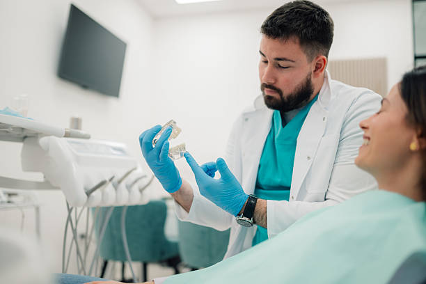 istock Dentist showing teeth model to patient in modern clinic 2213059051