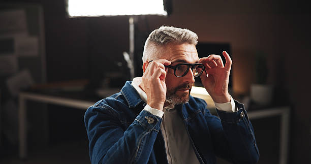 istock Business, night and man in office, glasses and thinking with problem solving for eyesight, creative and deadline. Mature person, graphic designer and artist in workplace, clear vision and pressure 2213059074