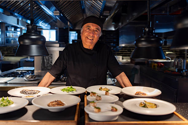 istock Portrait of a chef working at a restaurant and presenting plates while smiling 2213060073