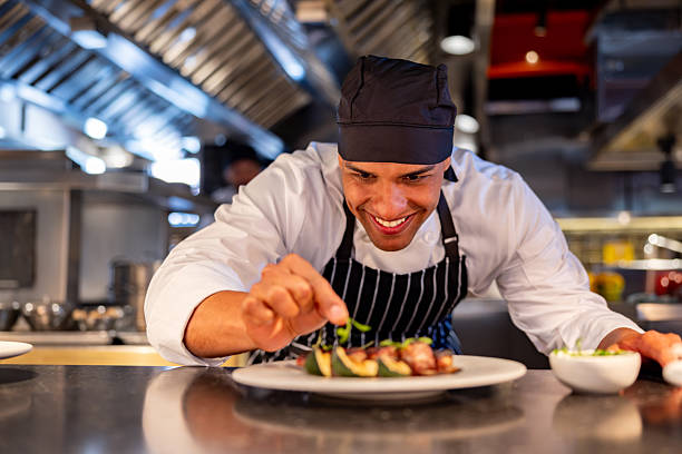 istock Happy chef decorating a plate while serving food at a restaurant 2213060119