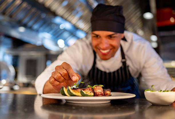 istock Happy chef having fun decorating a plate at a restaurant 2213060131