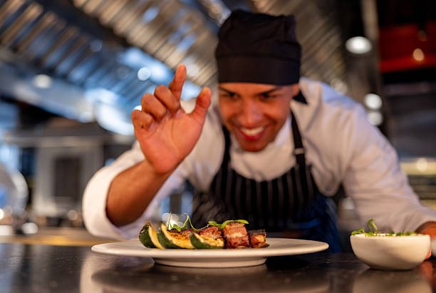 istock Chef working at a commercial kitchen and having fun decorating a plate 2213060147