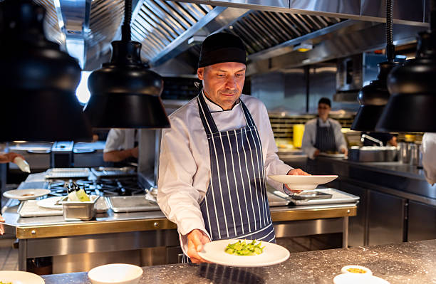 istock Chef working at a restaurant and serving plates on the kitchen counter 2213060150