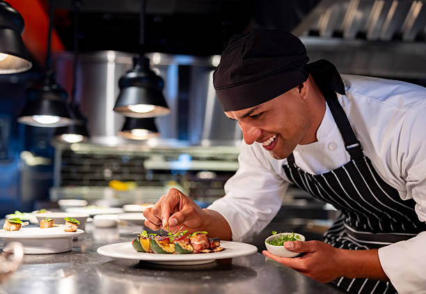 istock Happy chef decorating a plate while serving food at a restaurant 2213060151