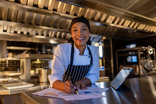 istock Happy chef doing the accountancy while working at her restaurant 2213060180
