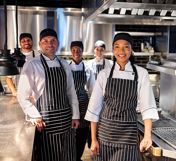 istock Happy group of cooks smiling while working at a restaurant 2213060194