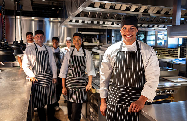 istock Happy chef leading a group of cooks at a restaurant 2213060199