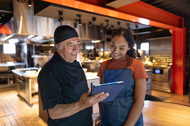 istock Chef explaining the menu to a waitress working at a restaurant 2213060234