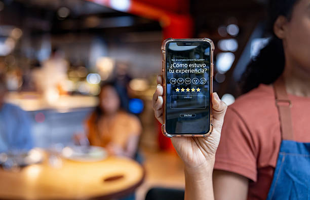 istock Waitress showing an app to rate the customer experience at a restaurant 2213060249
