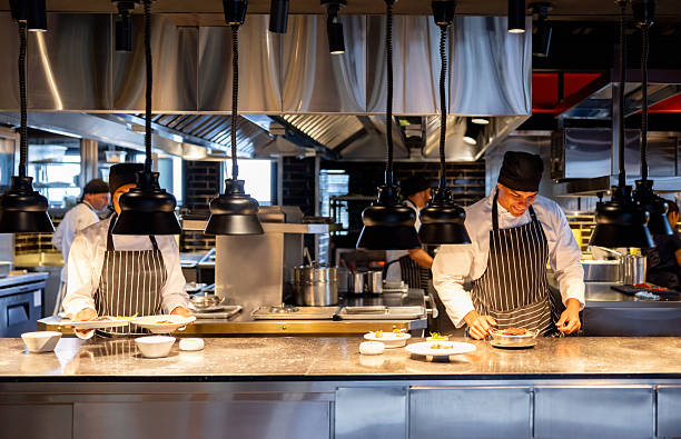 istock Team of chefs serving plates in a commercial kitchen 2213060250