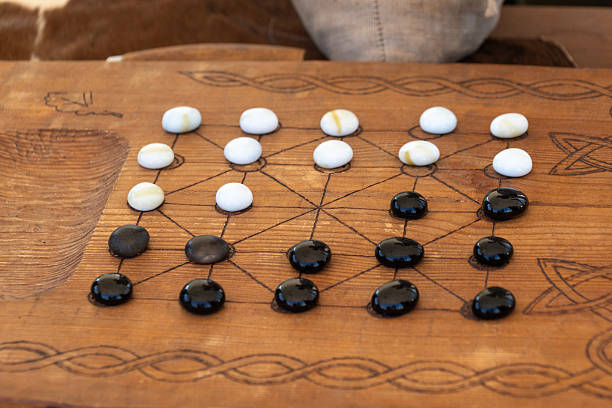 istock Vintage strategy board game with black and white stones on wooden table 2213061268
