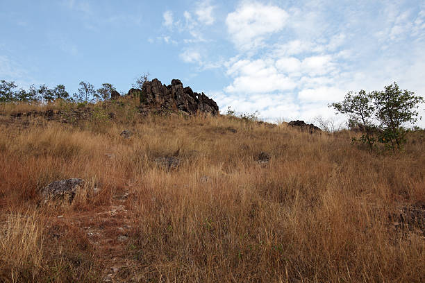 istock Rocky Landscape Under Bright Sky with Grassy Hills and Clouds 2213062537