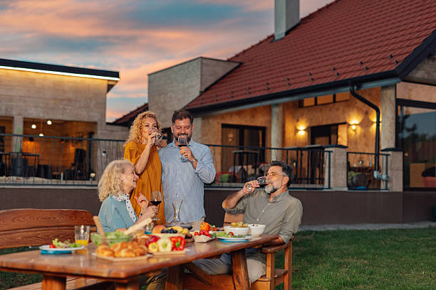 istock Family enjoying dinner and drinking wine in their backyard 2213062628