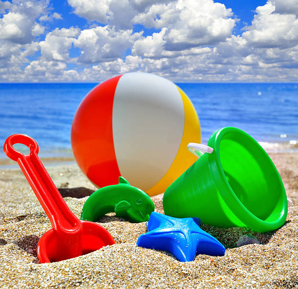 Baby Toys on the beach sand against a cloudy sky in a sunny, summer day