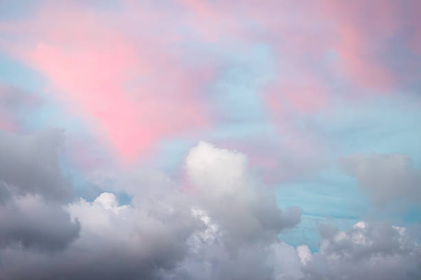 A cloud covered sky at sunset with hints of pink and blue