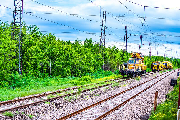 rail repair equipment on a new railway,Railway track machines.machines for building new rails Railway track equipment at cloudy spring skies in green scenery,Karnobat,Bulgaria,May 5th 2014
