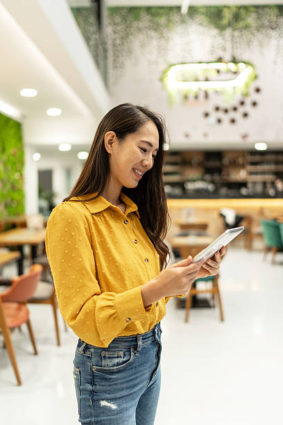 istock Young asian manager using digital tablet in modern office cafeteria 2213066957