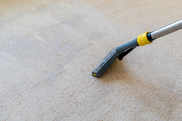 istock Carpet cleaning process with vacuum cleaner on beige rug 2213069945