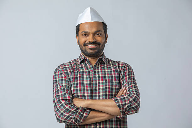 Portrait of smiling mid adult farmer wearing topi looking at camera while standing on white background