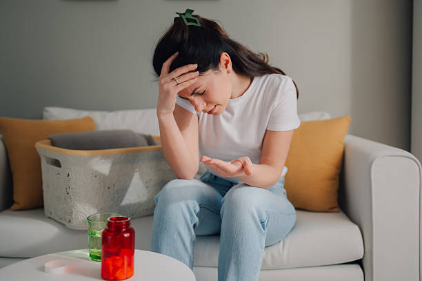 istock Young woman feeling sick at home and taking pills 2213080736