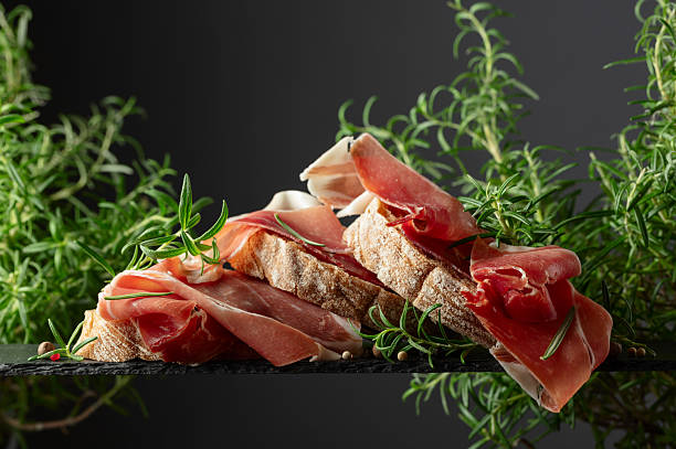 istock Ciabatta with prosciutto and rosemary on a black background. 2213083261
