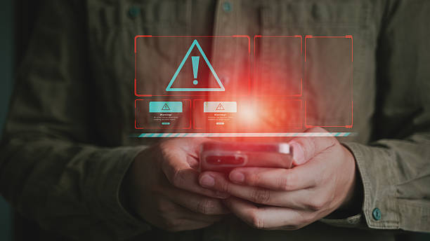 istock Cyber Alert Warning Interface on Red Holographic Display Held by Businessman. 2213085379