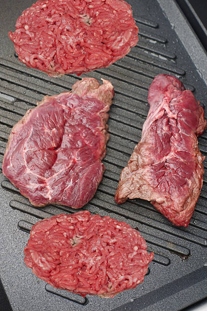 Grilled beef fillets and minced steaks being cooked on a griddle