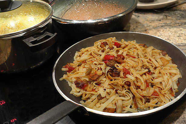 istock Tagliatelle pasta being cooked with ground beef meatballs and a vegetable ragout 2213085970