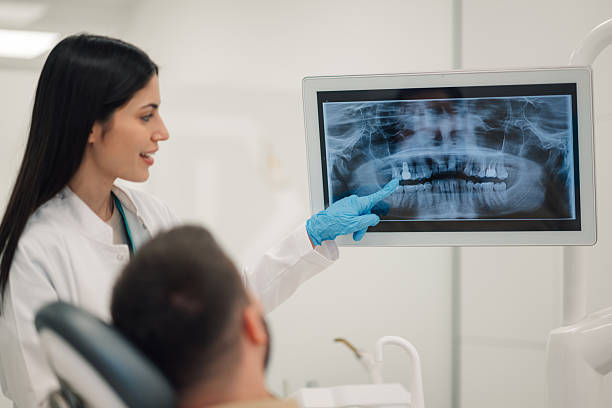 istock Dentist showing teeth x-ray to patient in modern clinic 2213087876