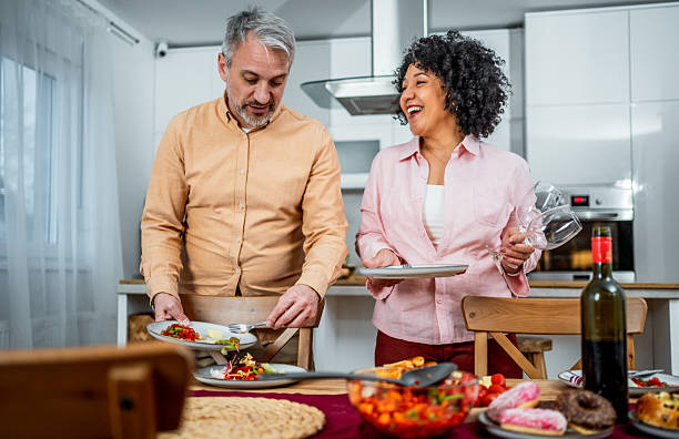 istock Mature couple preparing the table for lunch together in their kitchen 2213089335