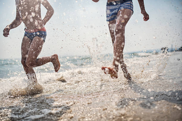 istock Two boys enjoying running by the sea 2213091625