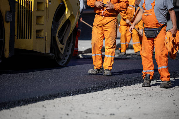 istock Construction workers laying asphalt on a busy road during daylight hours 2213096594