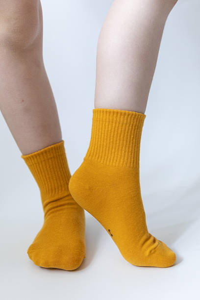 istock Baby feet in yellow socks on a white background 2213097759