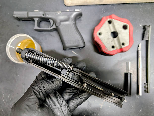 istock Professional firearm maintenance and cleaning: disassembling a pistol for thorough care and lubrication. 2213102803