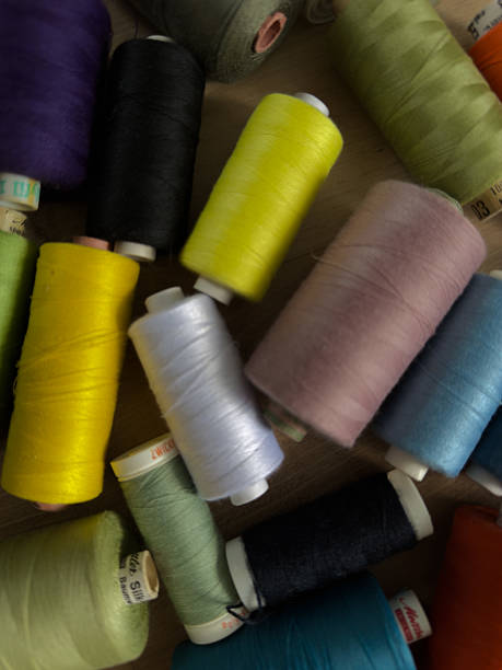 istock Colorful sewing threads arranged on wooden surface, assorted spools in various vibrant shades for textile, tailoring, or DIY projects, top view of craft supplies. 2213105388