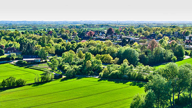 Patchwork field from above. Springtime green farm land and village