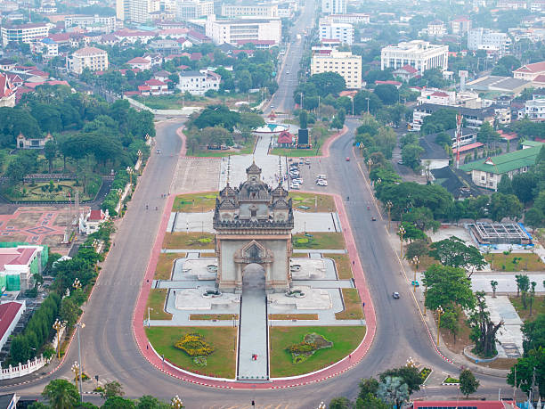 An aerial view of Vientiane, Laos, with the prominent Patuxai Victory Monument at the center of a bustling avenue.