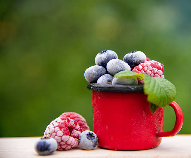 Mix of fresh berries in the yoghurt or cream. Top view.