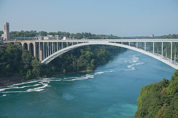 istock A bridge spans a river with a green forest on the other side. The bridge is white and spans the entire width of the river 2213111391