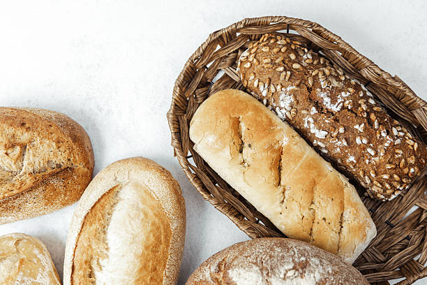 istock Freshly baked bread assortment in a rustic basket on a neutral background 2213122826