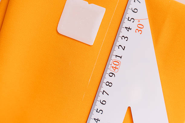 istock A large ruler and a chalk close-up lie on an orange fabric 2213129489