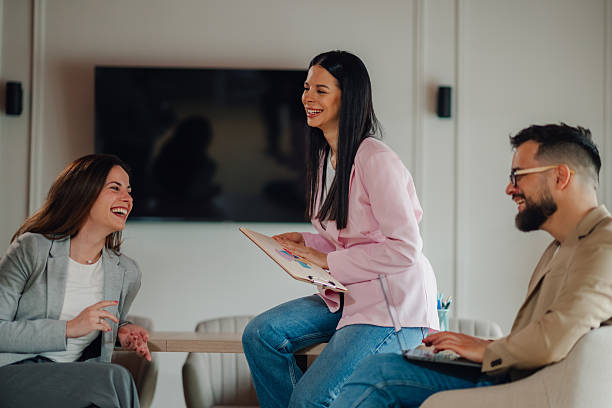istock Young businesspeople laughing during a work meeting showing positive data 2213130058
