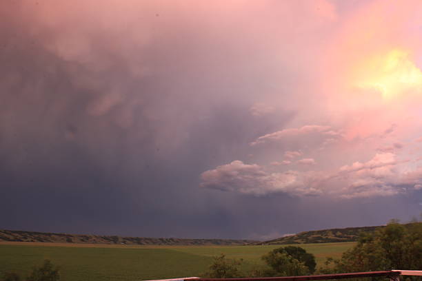 Storm clouds in the sky, rain on the horizon, summer season. Two rainbows