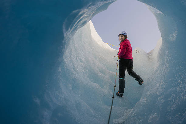 istock Woman exploring glacial crevasse, using rope and crampons 2213132940